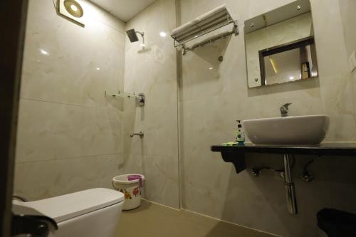 a bathroom with a shower and a toilet and a sink at Hotel Taj Venture Agra in Agra