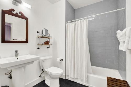 a white bathroom with a toilet and a sink at Above Broughton St 3002 in Savannah
