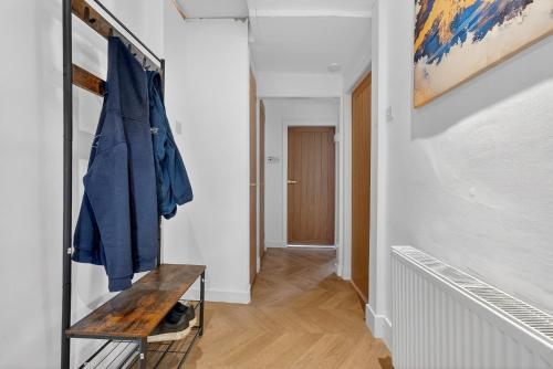 a hallway with a blue jacket hanging on a wall at Seaside Snug in Largs