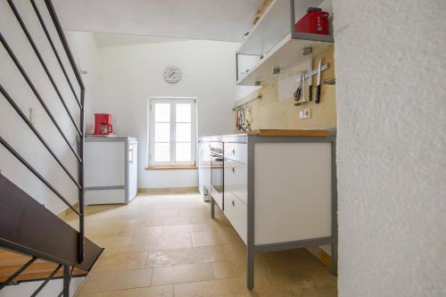 a kitchen with white cabinets and a staircase at Nengshof Ferienhaus Gänseblümchen in Wißmannsdorf