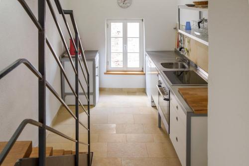 a kitchen with white counters and a stairway at Nengshof Ferienhaus Gänseblümchen in Wißmannsdorf