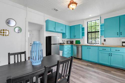 a kitchen with blue cabinets and a table with chairs at The Tilted Texan in Buda
