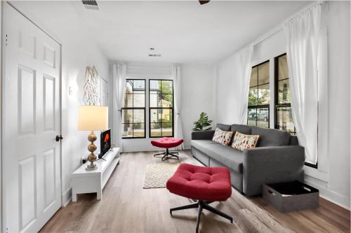 a living room with a couch and a red chair at The Tilted Texan in Buda