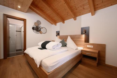 a bedroom with a bed with a wooden headboard at Apart Marie-Therese in Umhausen
