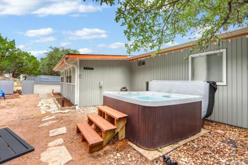 a hot tub sitting in a yard with a bench at The Summit in Wimberley