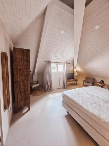 an attic bedroom with a bed and a window at Coconuts Tropical Boutique Hotel Curaçao in Willemstad