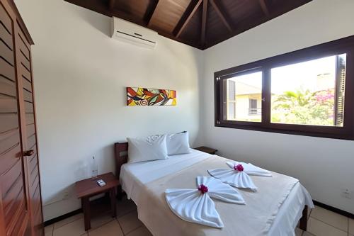 a bedroom with a bed with two pillows on it at Casa Morrinhos 17 in Garopaba