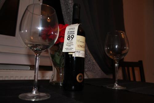 a bottle of wine sitting on a table with two glasses at Fair Trade Apartment in Düsseldorf