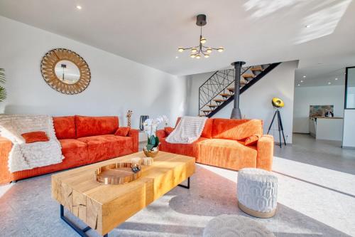 a living room with orange furniture and a coffee table at BELLEVUE 1, piscine, jacuzzi, sauna in Champcevinel