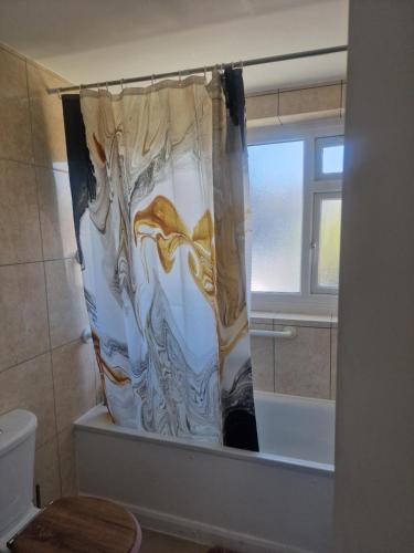 a shower curtain in a bathroom with a toilet at Oakfield Gardens NY in Edmonton