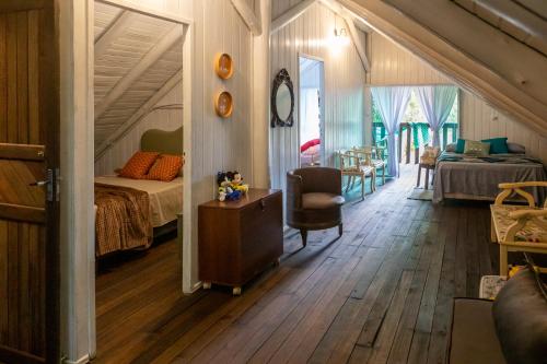 a bedroom with a bed and a chair in a room at Sítio Temporada in Guabiruba