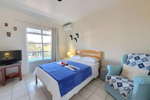 a small bedroom with a bed and a chair at Condomínio Villa do Oceano in Garopaba
