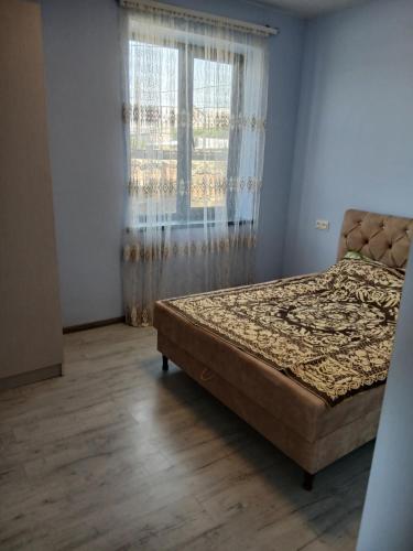 a bedroom with a bed and a window at Апартамент in Yerevan
