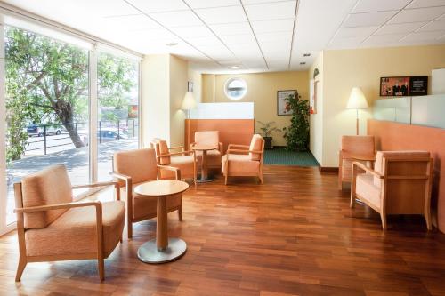 a waiting room at a hospital with chairs and tables at Ibis Murcia in Murcia