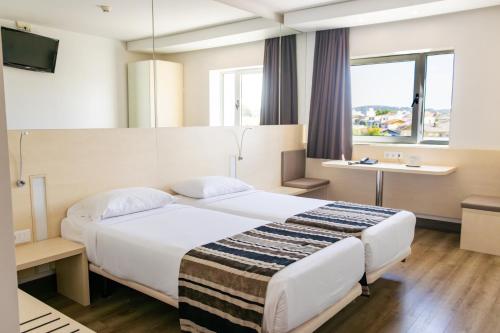 a hotel room with a large bed and a window at Park Hotel Porto Valongo in Valongo