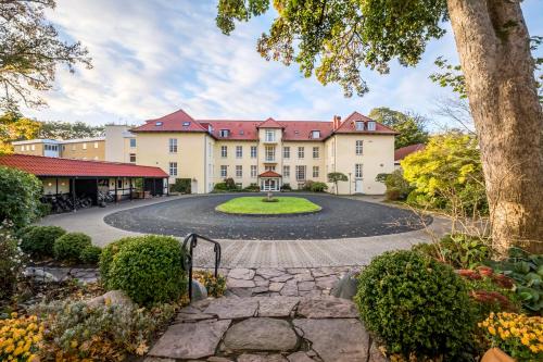 an exterior view of a large building with a circular driveway at Gl Skovridergaard in Silkeborg