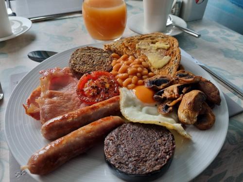 a plate of breakfast food with eggs sausage and toast at Bellavista Guest House in Kirkwall