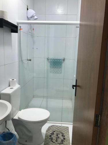 a bathroom with a toilet and a glass shower at Pousada Madre De Deus in Brejo da Madre de Deus