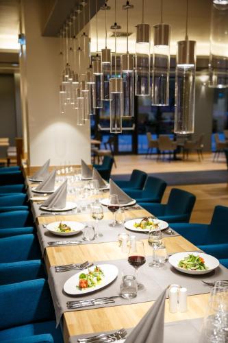 a long table with plates of food and wine glasses at HVD Grand Hotel Suhl Business & Leisure in Suhl