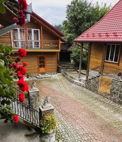 a house with a fence and flowers on a brick road at Топірець in Vorokhta