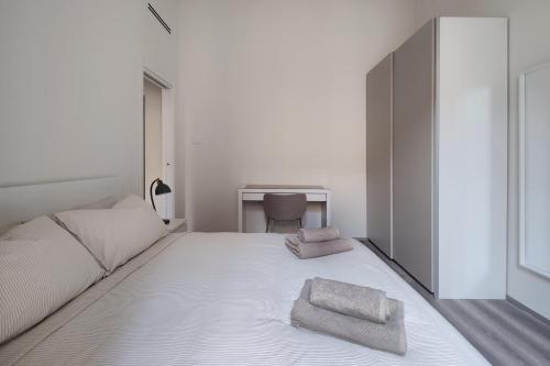 a bedroom with a bed with two towels on it at Otto Violini - City Center in Cremona
