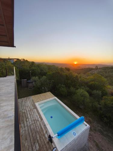 a swimming pool with a sunset in the background at Villa Toscana I - Gran Vista y Tranquilidad in Villa Serrana