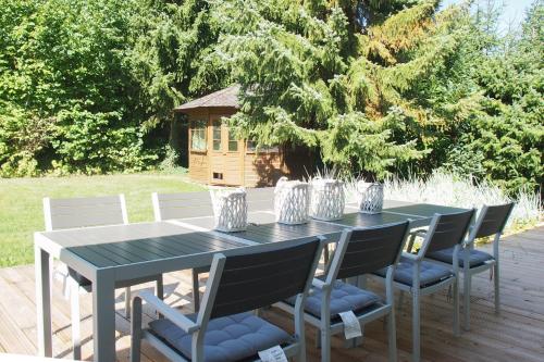 a table with chairs and a bird house on a deck at Weedkroog in Timmendorfer Strand