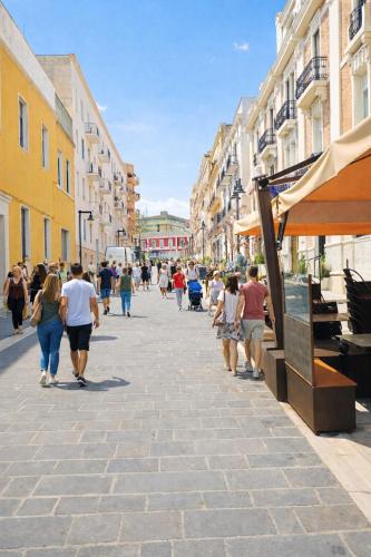 a group of people walking down a city street at Le Gemme Rooms in Matera