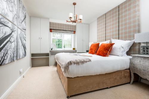 a bedroom with a large bed with orange pillows at LUXURIOUS Country Rooms in Hurley - THE FOX in Hurley