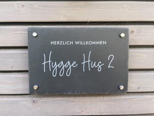 a sign on a wooden wall with the words hopsy huguez at Hygge Hus 2 in Timmendorfer Strand
