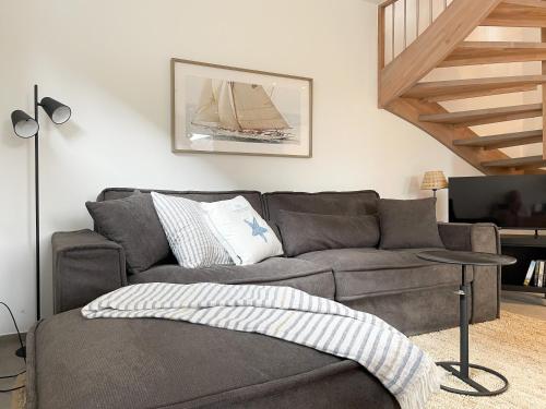 a living room with a gray couch and a table at Hygge Hus 2 in Timmendorfer Strand