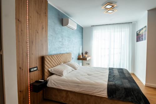 a bedroom with a bed with a blue wall at Elite Luxury Crib in Cluj-Napoca