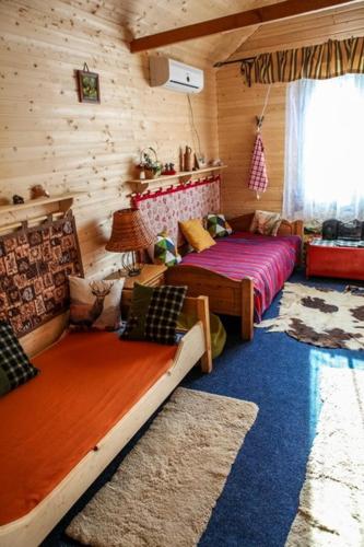 a bedroom with two beds in a log cabin at Görbe Vendégház in Tarcal