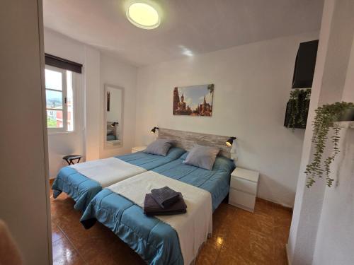 a bedroom with a large bed with blue sheets at Alojamiento La Concha in Las Lagunas