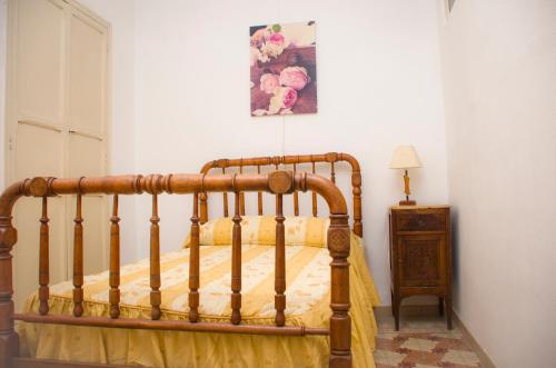 a bed with a wooden frame in a bedroom at Casa Marifina in Enguera