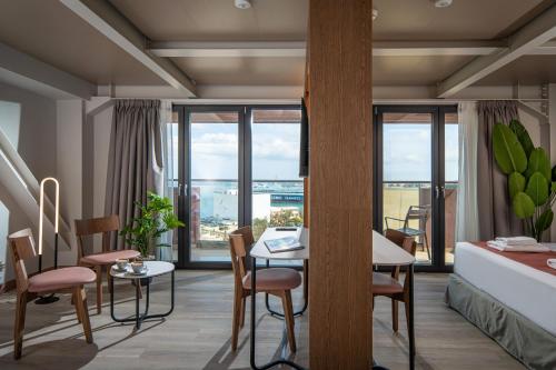 a living room with a table and chairs and a bed at Infinity City Boutique Hotel in Heraklio
