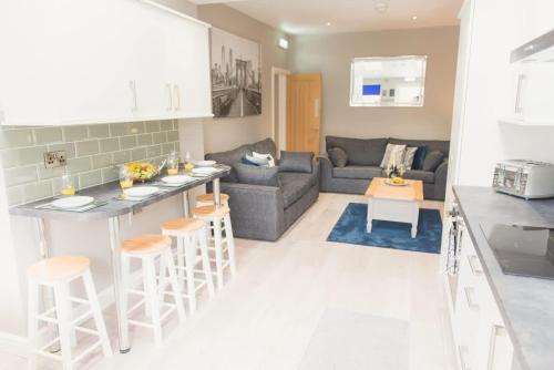 a kitchen and living room with a couch and a table at LYNNTON HOUSE Stunning 6 bed Town Centre House ALL with En-Suites Prime Location Tamworth in Tamworth
