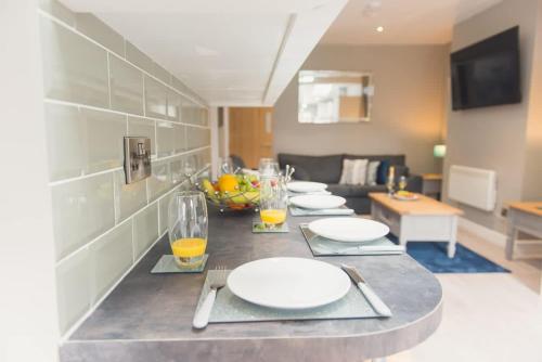 a table with white plates on it in a living room at LYNNTON HOUSE Stunning 6 bed Town Centre House ALL with En-Suites Prime Location Tamworth in Tamworth