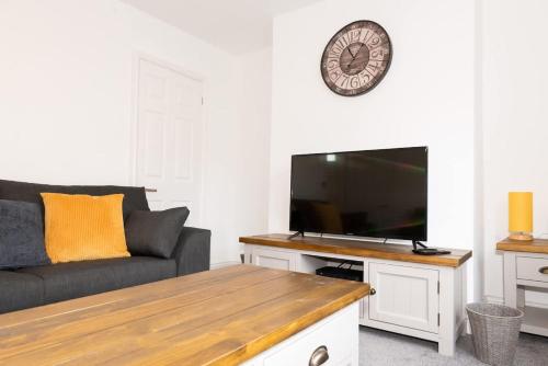 a living room with a couch and a flat screen tv at Argyle House Stunning 2 Bed Town Centre Home from Home with Private Parking in Tamworth