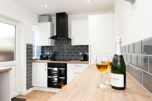 a bottle of wine and a glass on a kitchen counter at Argyle House Stunning 2 Bed Town Centre Home from Home with Private Parking in Tamworth
