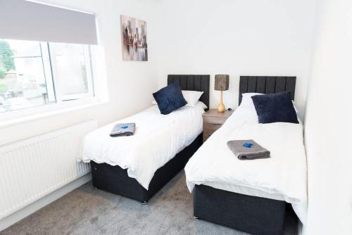 two beds sitting next to each other in a bedroom at Argyle House Stunning 2 Bed Town Centre Home from Home with Private Parking in Tamworth