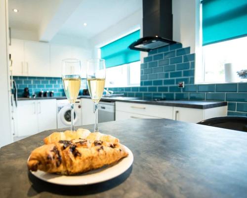 a table with two glasses of white wine and a pastry at Halford House 3 Bed Town Centre Home from Home with Parking for 2 cars Prime Location Tamworth in Tamworth
