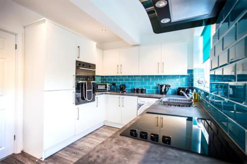 a kitchen with white cabinets and a sink at Halford House 3 Bed Town Centre Home from Home with Parking for 2 cars Prime Location Tamworth in Tamworth