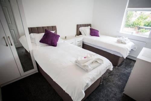 two beds in a room with purple pillows at Halford House 3 Bed Town Centre Home from Home with Parking for 2 cars Prime Location Tamworth in Tamworth