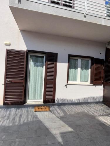 a building with brown shuttered windows and a door at La casa di Fiore in Vico Equense