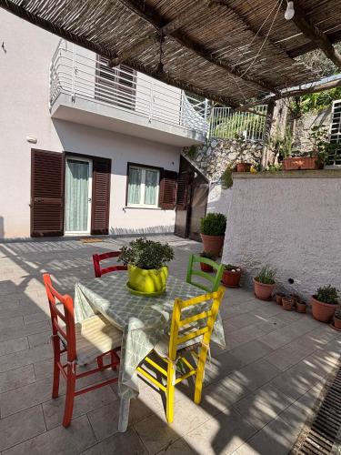 a patio with a table with chairs and a plant on it at La casa di Fiore in Vico Equense
