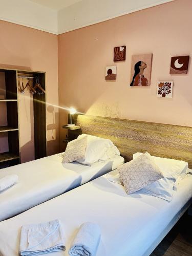 two beds in a hotel room with two beds at La Carpe d'Or in Fontainebleau