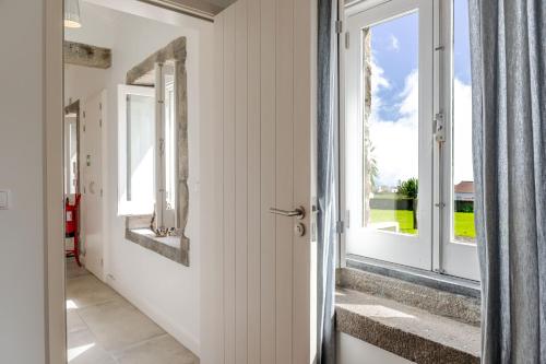 a hallway with a door and a window at Casas do Forneiro - T1 in Nordeste