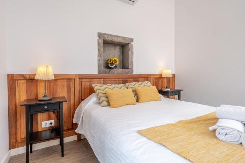 a bedroom with a bed with two night stands and two lamps at Casas do Forneiro - T1 in Nordeste