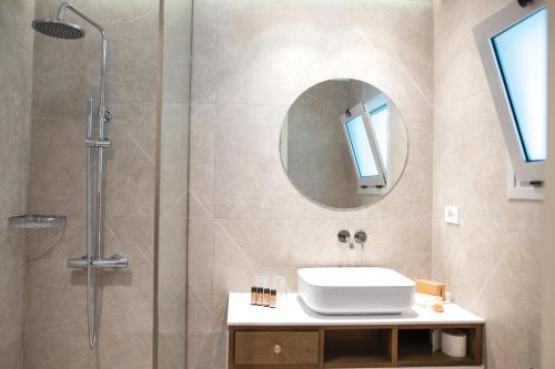 a bathroom with a shower and a sink and a mirror at Atlantis Hotel in Kos